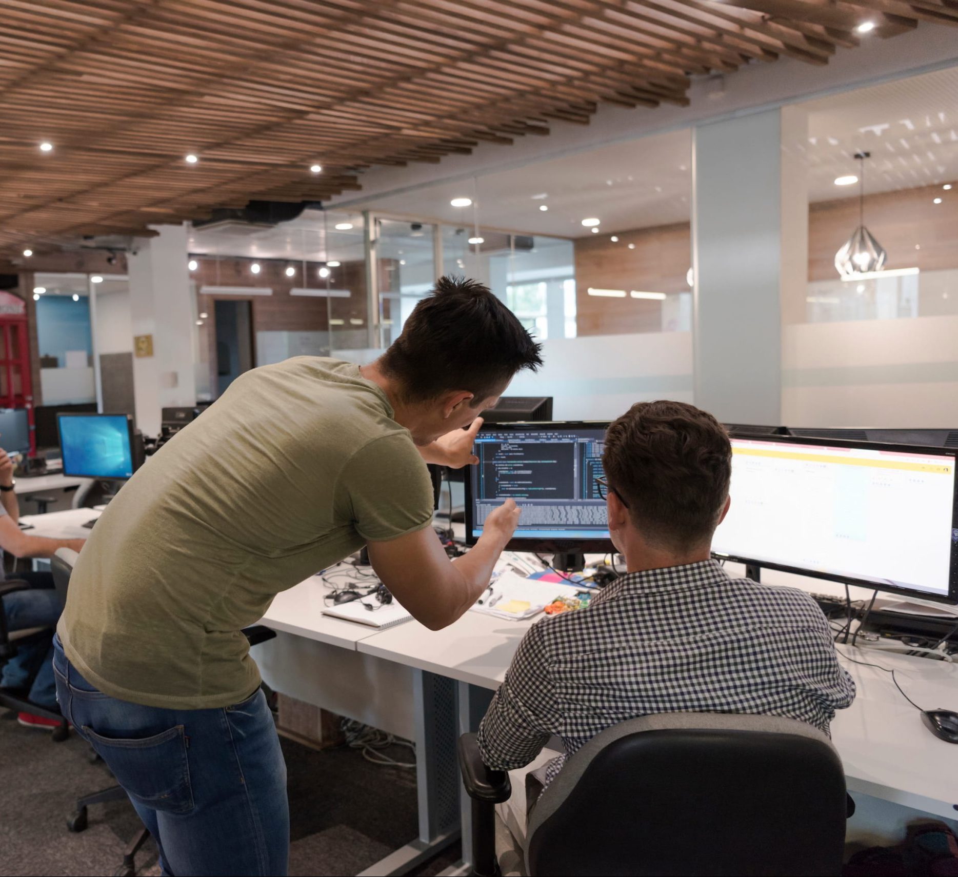 Two professionals collaborating at a workstation on IoT technology in a modern office environment.