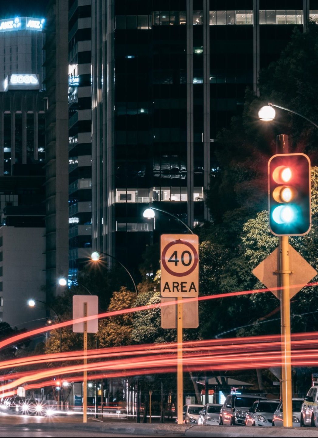 Night time city image showing traffic lights and blurred moving traffic with buildings in background